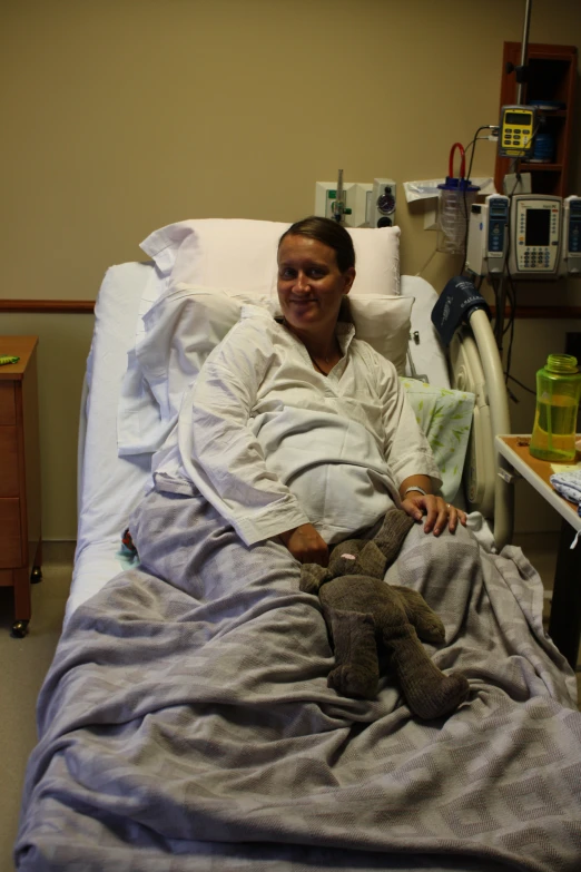 a woman smiling in a hospital bed