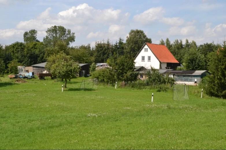 a picture of a beautiful green grassy field with houses