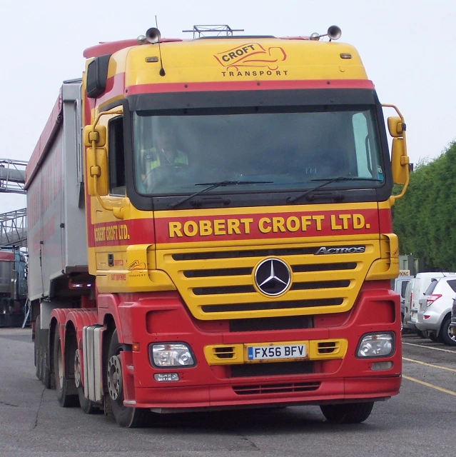a yellow and red truck with yellow letters on it