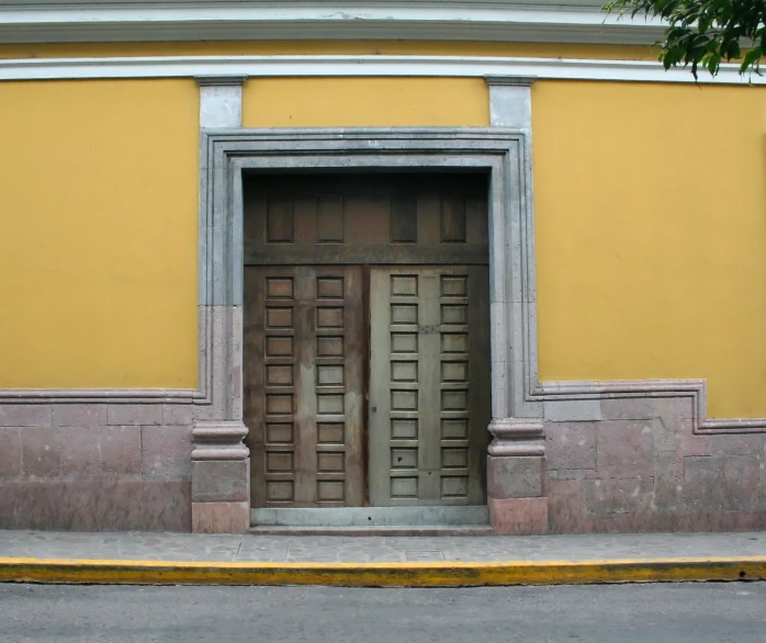 a yellow wall with two open doors on it