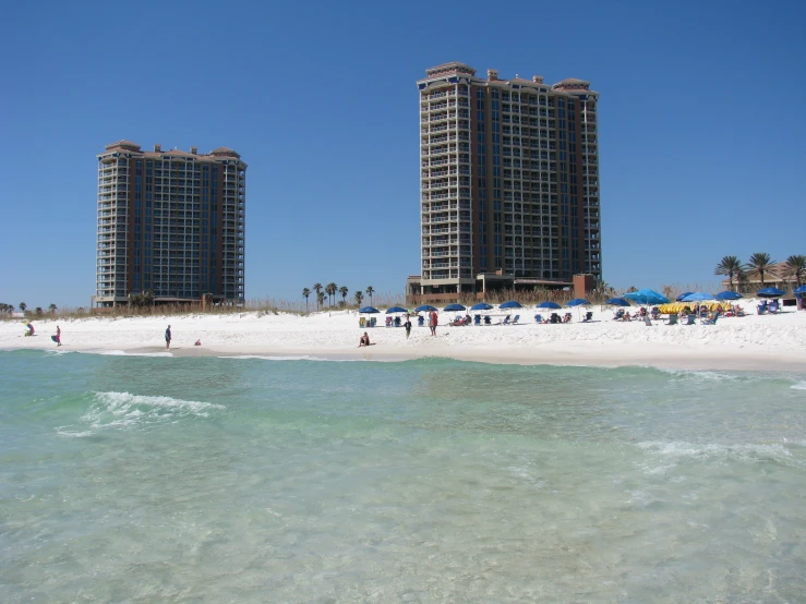 a sandy beach with a lot of people near the ocean