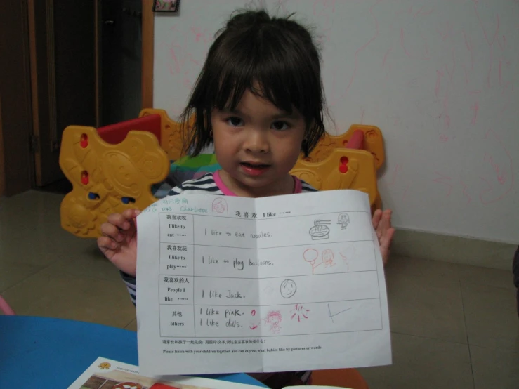 a child showing a chinese worksheet to her friend