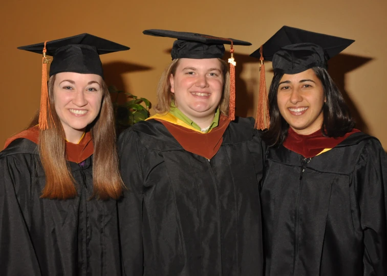 three women with a graduation cap and gown