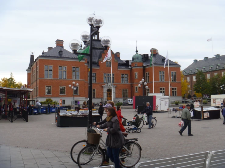 the woman is riding her bike past an old brick building