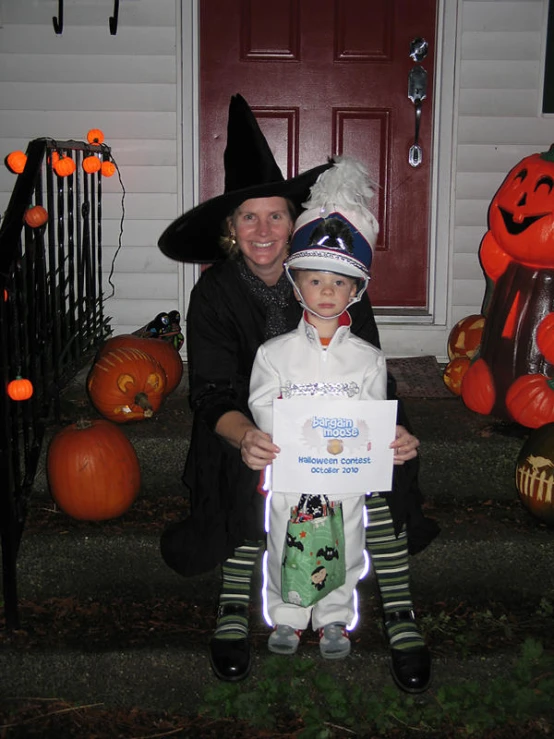 a woman holding a young child in a halloween costume