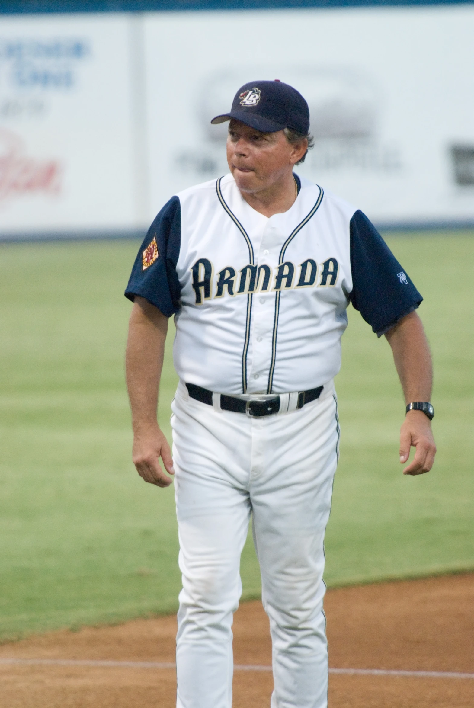 a baseball player in uniform walks on the field