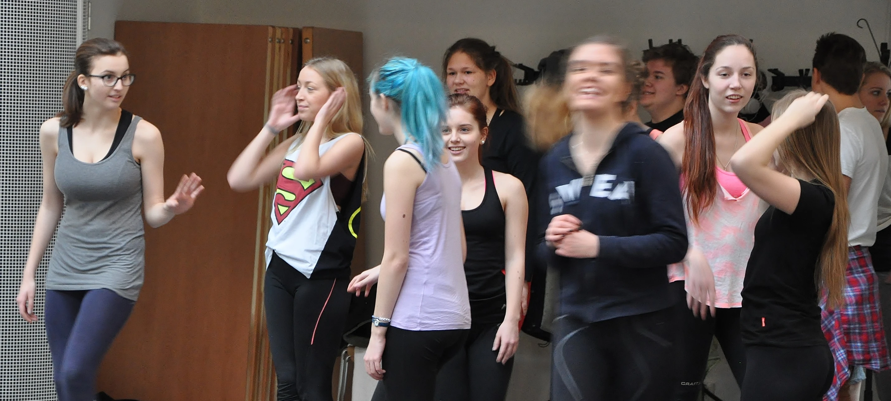 a group of young people stand outside in front of a door