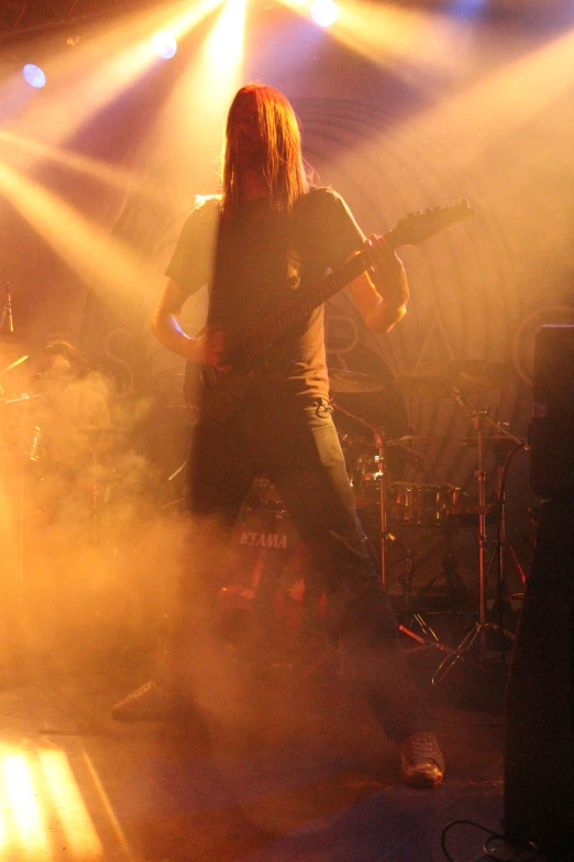 the person is playing an electric guitar in front of some smoke