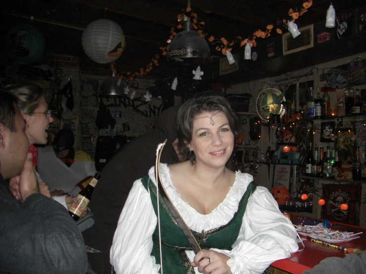 woman standing in front of a bar with people behind her