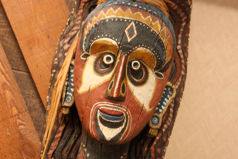 a wooden mask with multiple colors and markings