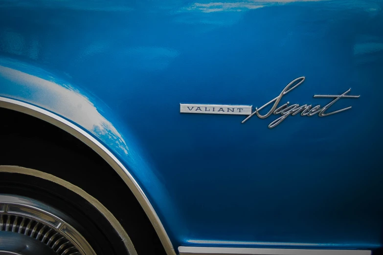 the emblem on the front of an antique blue mustang