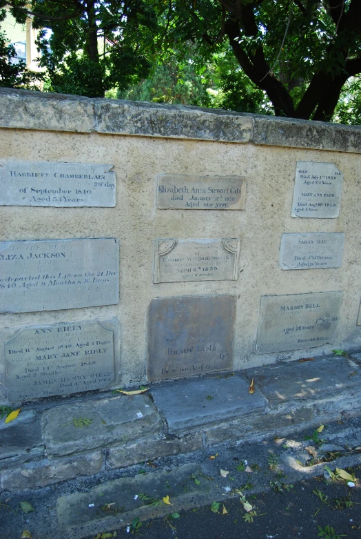 a stone wall with different names of people