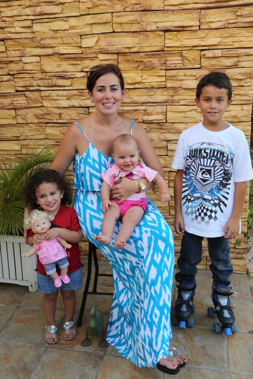 a woman sitting on a chair with two boys and a baby