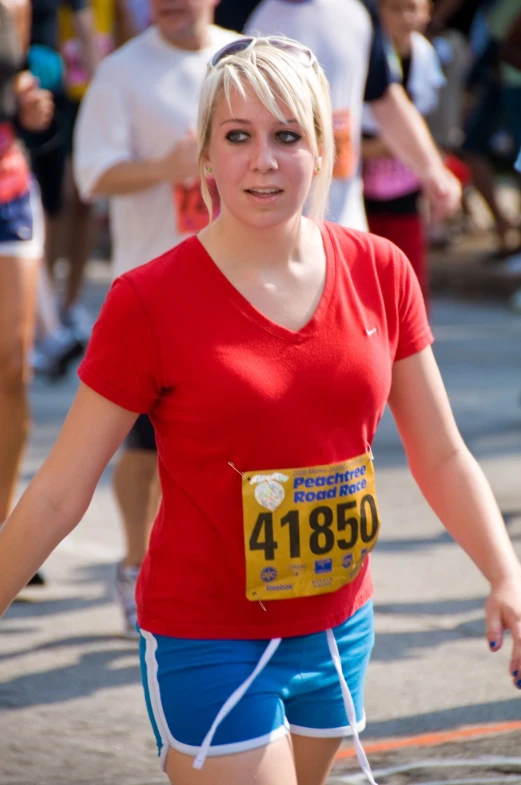 there is a woman wearing a red shirt and shorts