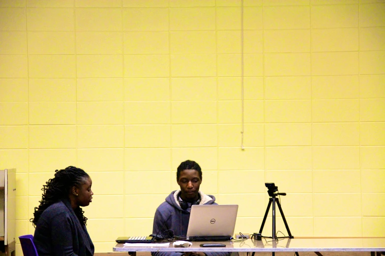 people in a conference room with a camera and laptop