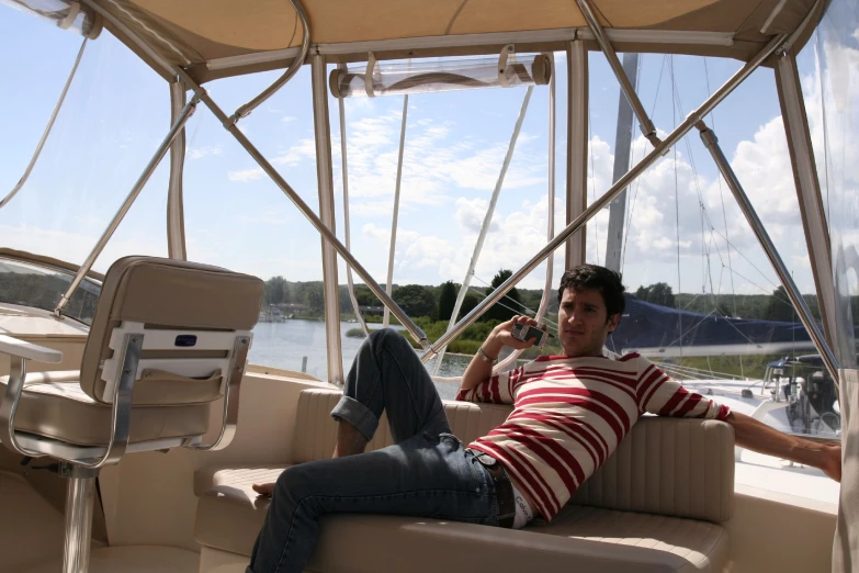 man sitting on a boat drinking a drink