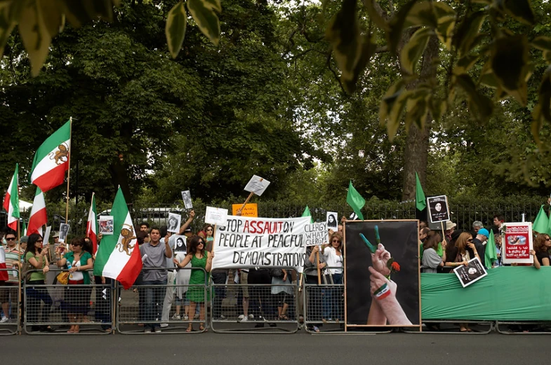 people protesting in front of an israeli fence