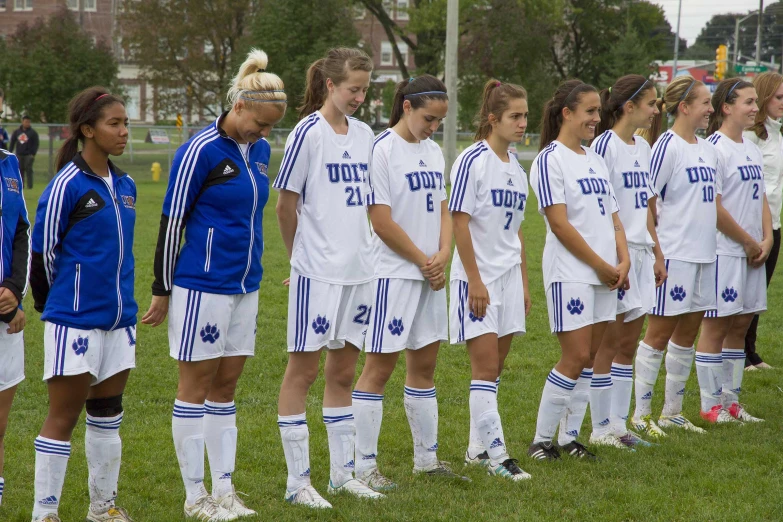 group of young women standing on field next to each other