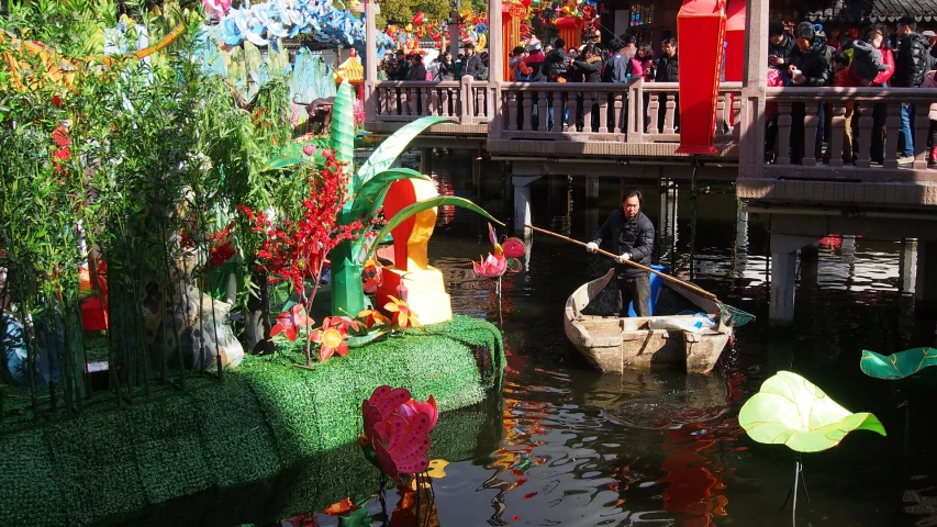 a river with lots of flowers near a building