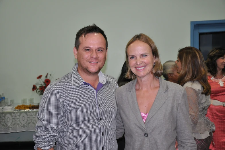 two people standing next to each other at a party