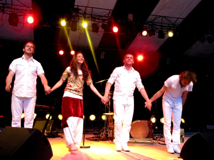 several people dancing on stage, lights and music