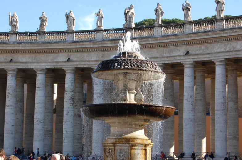 the large fountain is near a building with many statues