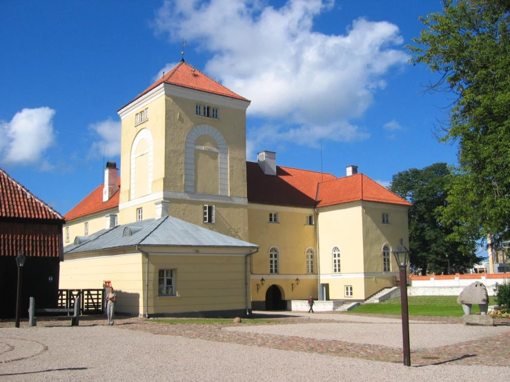 a large yellow building with an orange roof