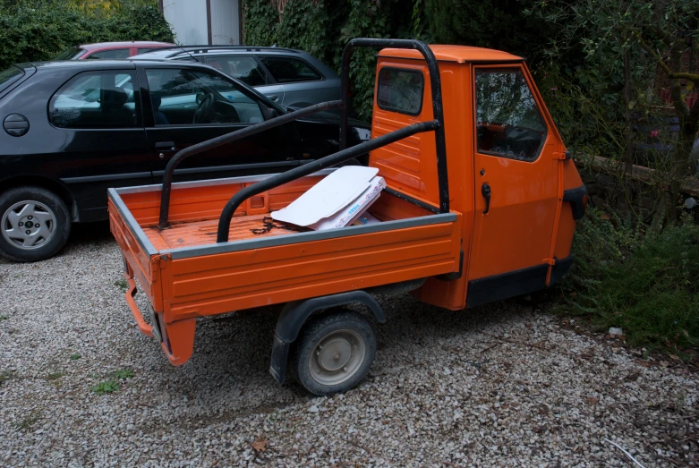 an orange truck has been parked in front of other cars