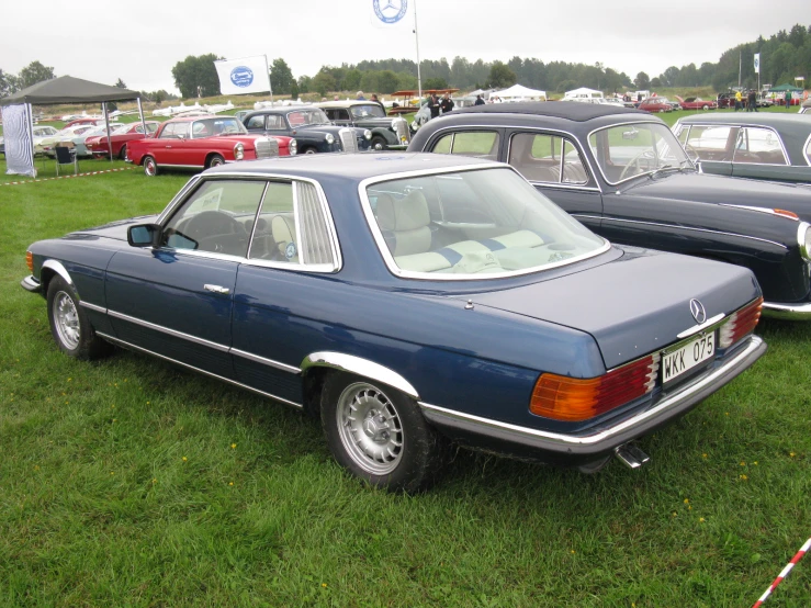 several old cars sit parked in a row