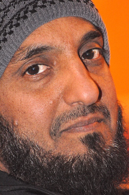 an indian man wearing a hat with long hair