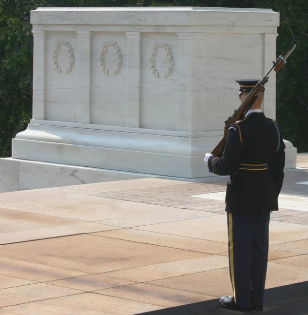 a man in uniform playing a bagpipe and an officer standing in front of a monument