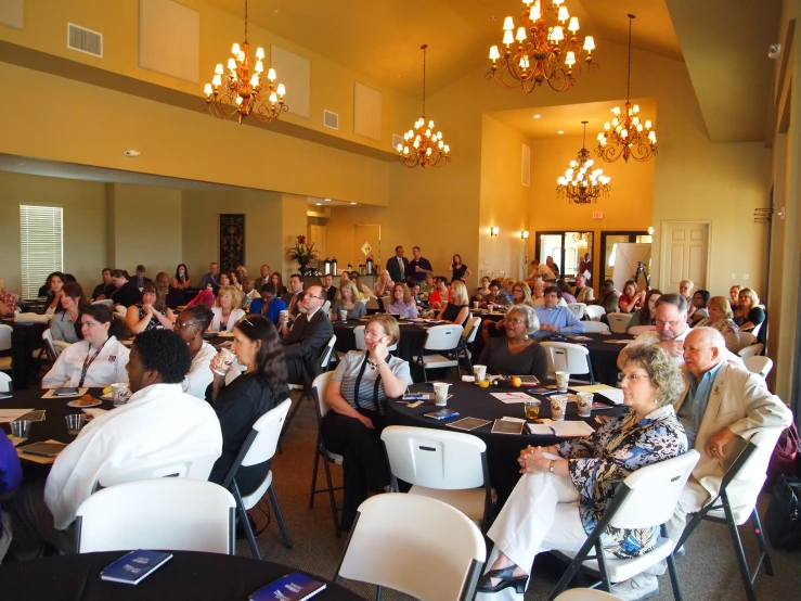 people sitting at tables in a banquet hall