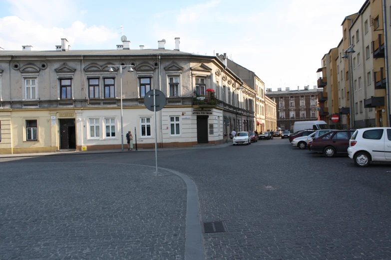 cars are parked along the street outside of buildings