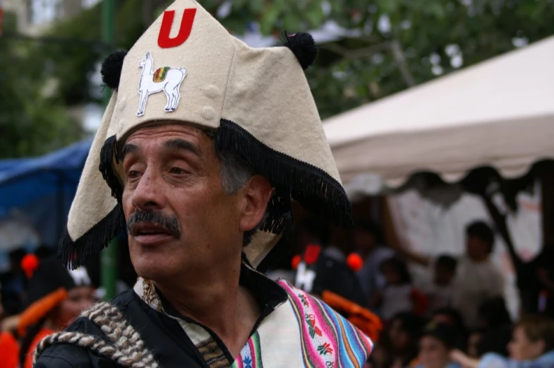 man dressed in native american clothing and headdress, staring at the camera