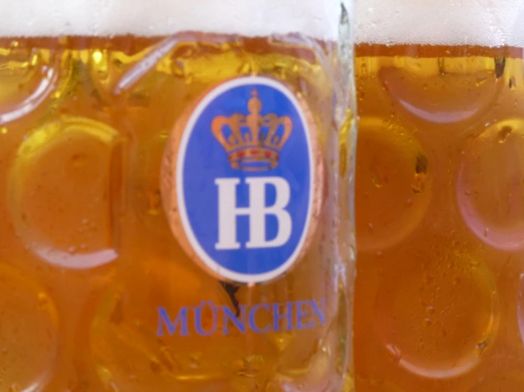 glasses filled with beer and the letter b and crown on it