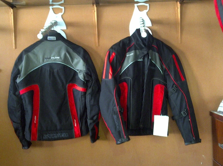 two jackets on display in a store, one with a white lace on it