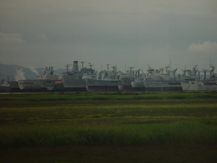 several large ships and buildings on an open field