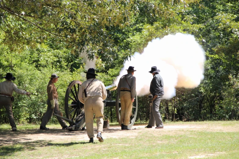 men are standing around near two old cannon guns