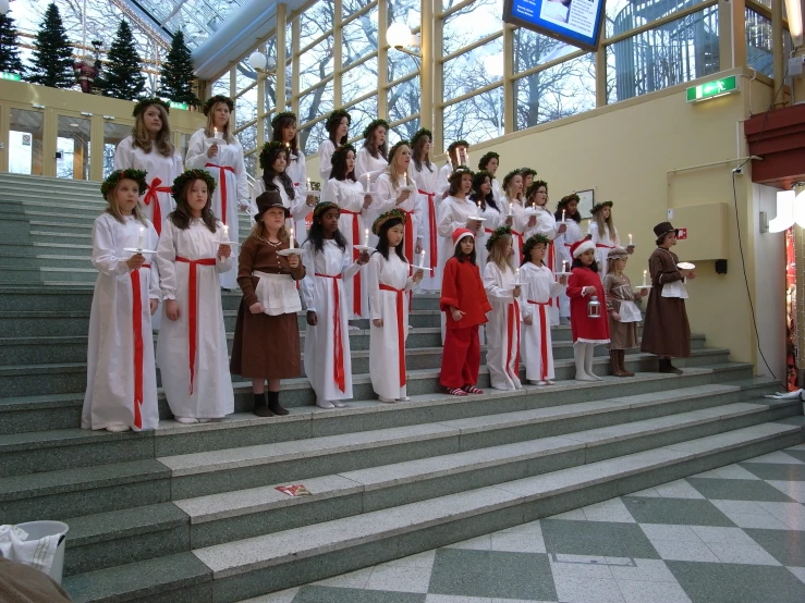 many people in red and white clothing standing on steps