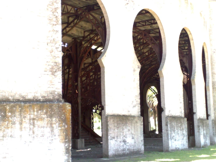 a building with arches and a clock that reads 4 15