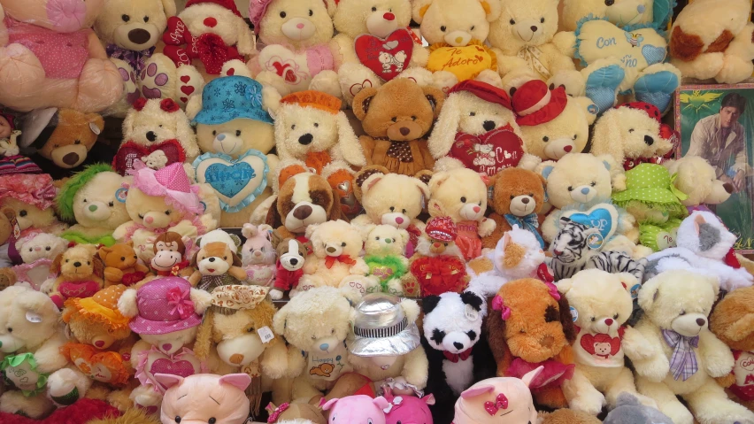 a large collection of stuffed animals sits among other teddy bears