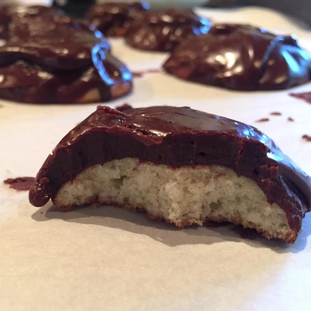 chocolate - covered donuts with coconut on top are shown