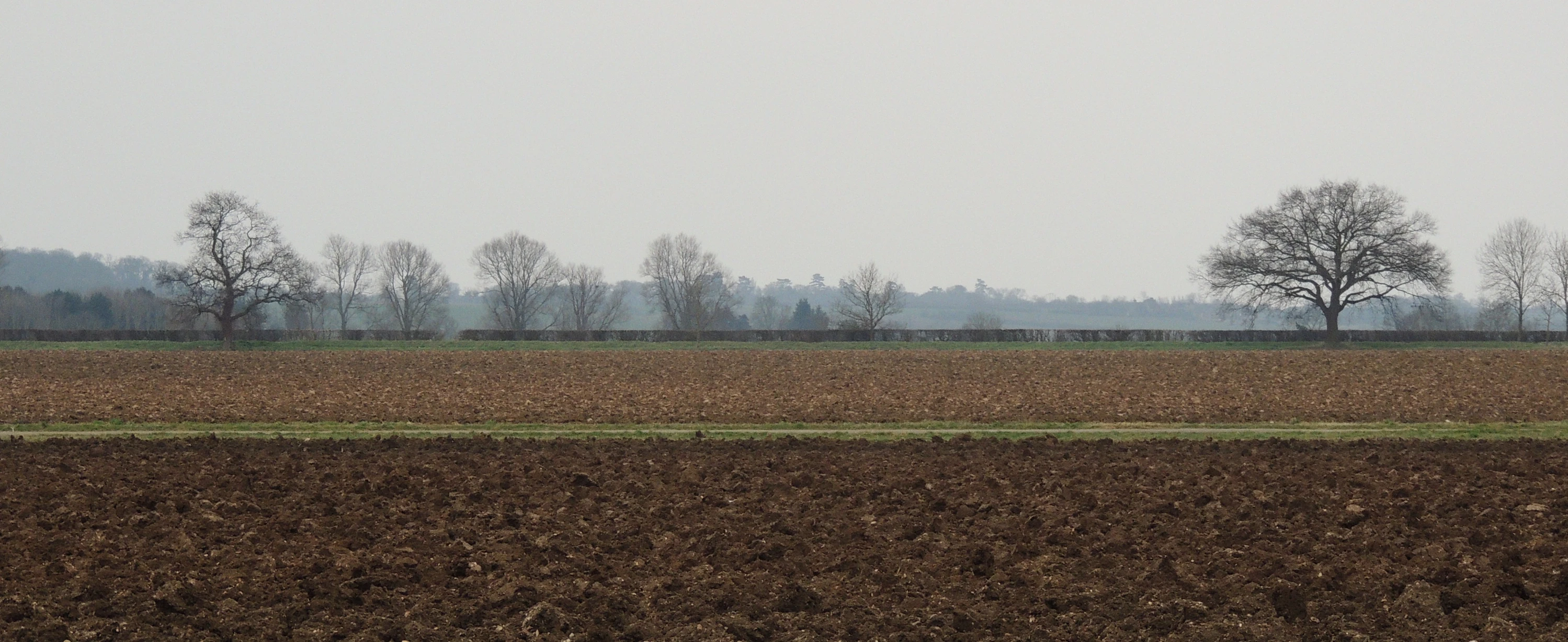 the tractor is plowing the farm field