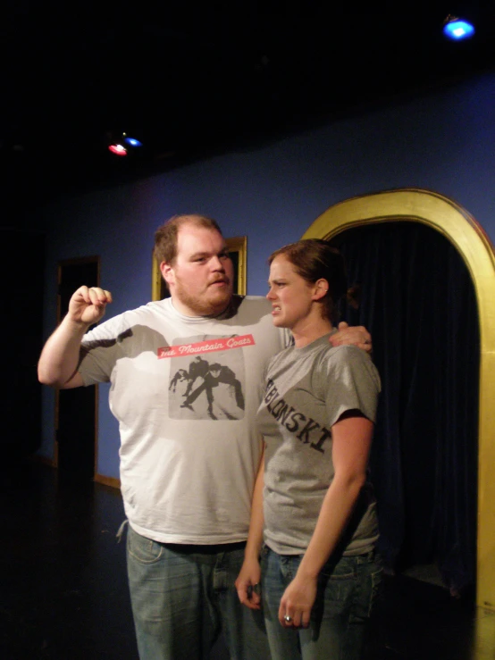 man and woman standing in room holding up a remote