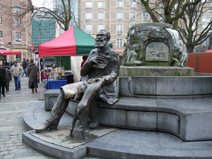 a statue of a man sitting next to a stone structure