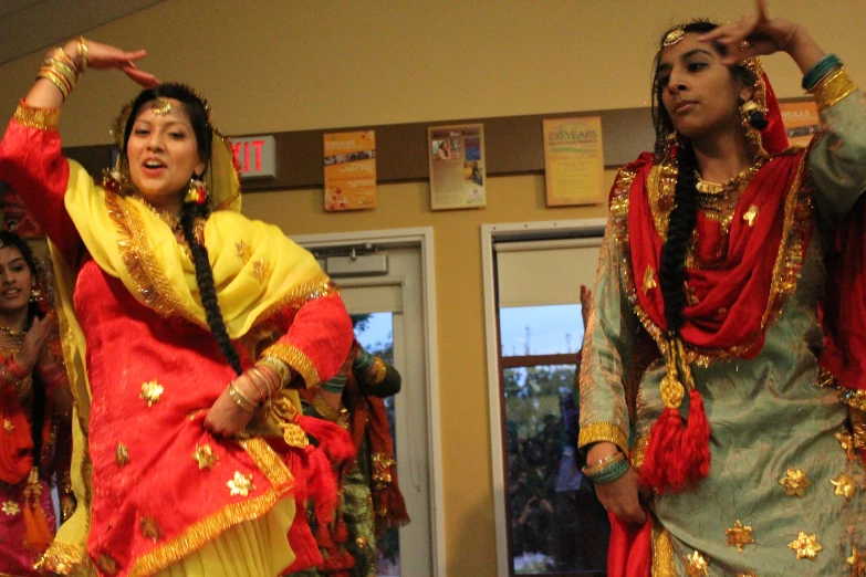 some women dressed in indian attire dancing together