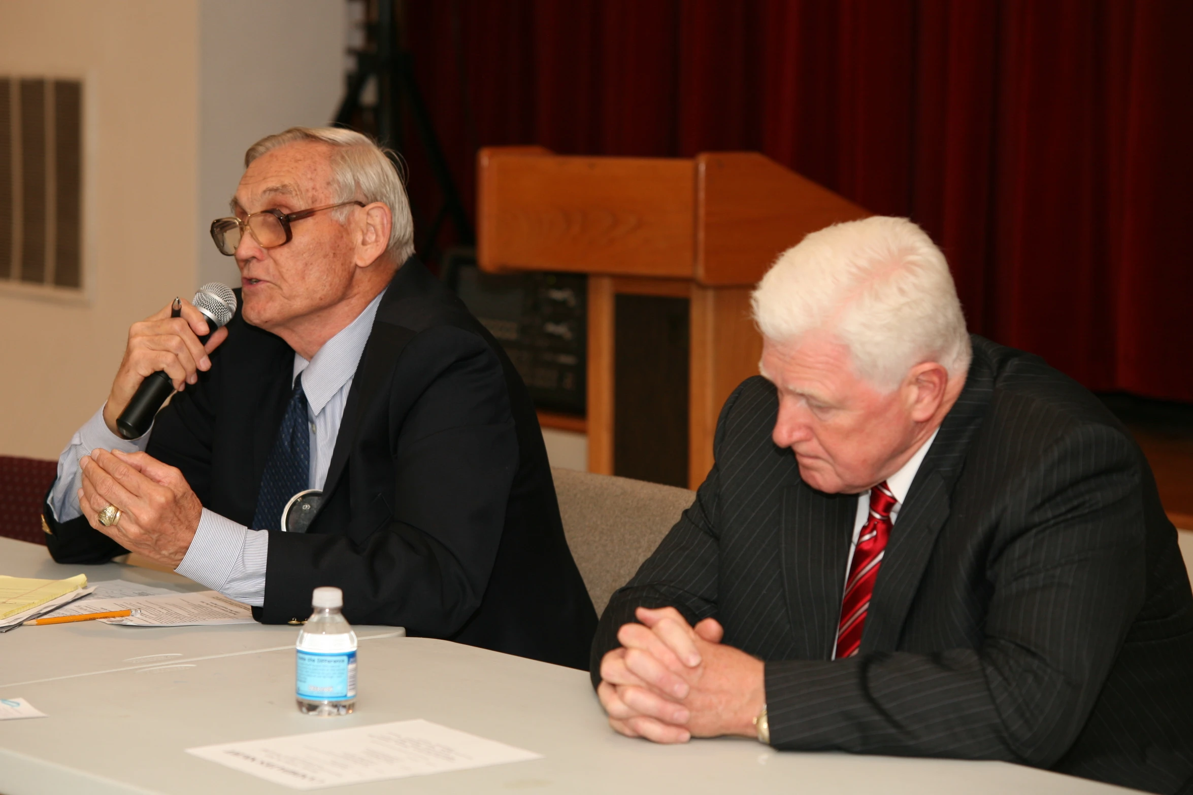 a man sits next to a man with a microphone in front of them