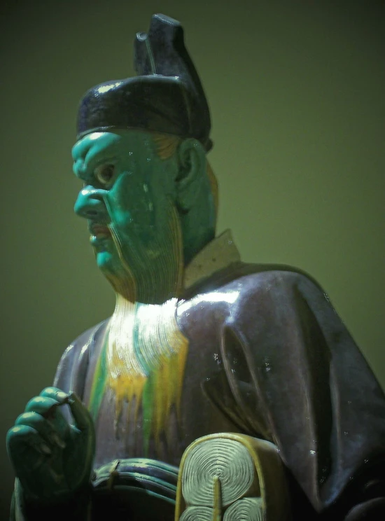 the statue is painted green and blue with gold accents