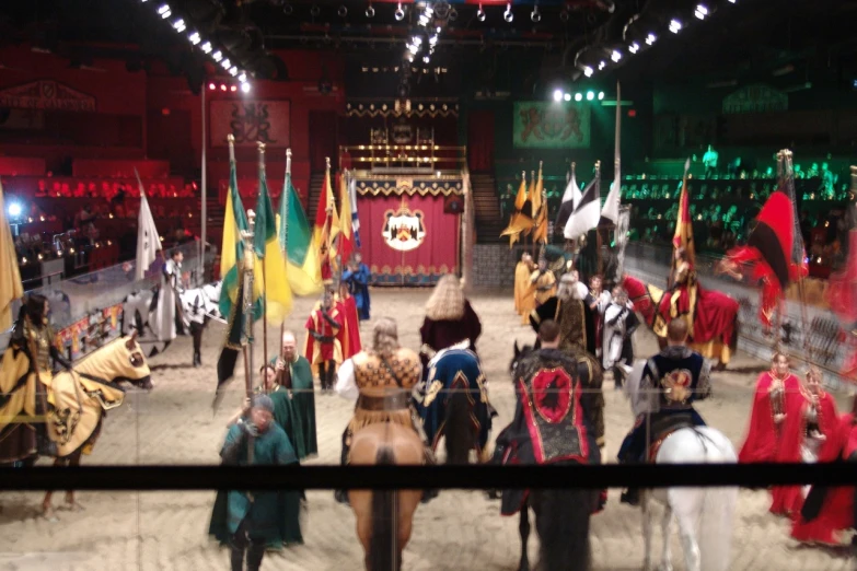 a group of people dressed in ancient style clothing walk around a courtyard