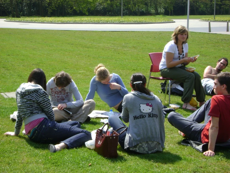 a group of people sitting in a field of grass